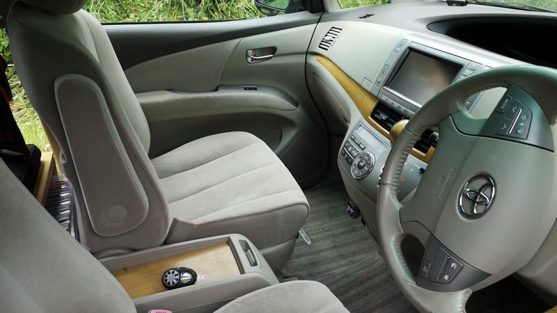 Front seats, steering wheel and centre console of the HMC107 Toyota Estima campervan