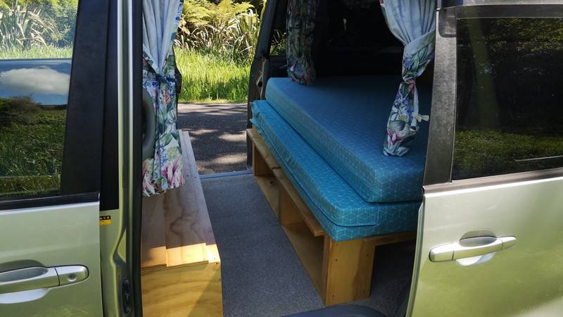 Side door open on the FYC899 campervan, bed cushions on the timber base with the bench alongside