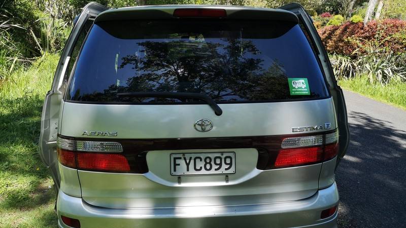 Back of the silver Toyota Estima campervan with registration FYC899 and the green self-contained sticker