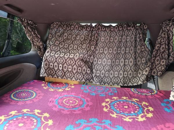 Inside the FPS382 campervan with the rear curtains closed and the bed made up