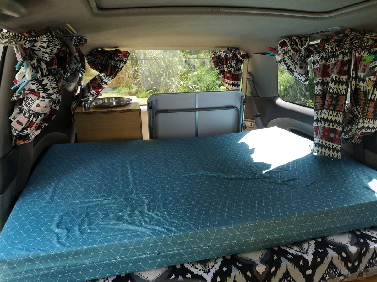Inside the FQK81 campervan looking forward over the bed to the sink unit and the seat backs