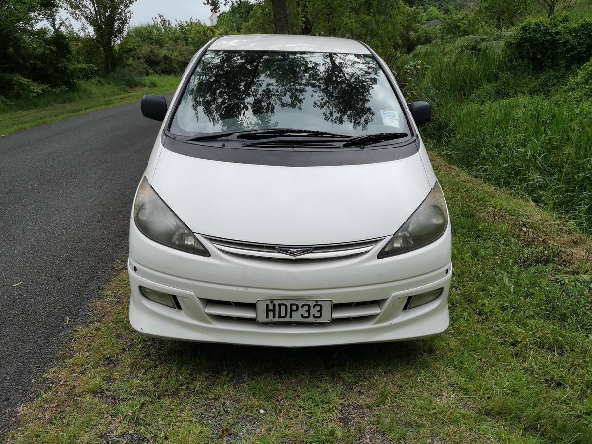 Front of the white 2001 Toyota Estima campervan with registration HDP33, parked on a grass verge