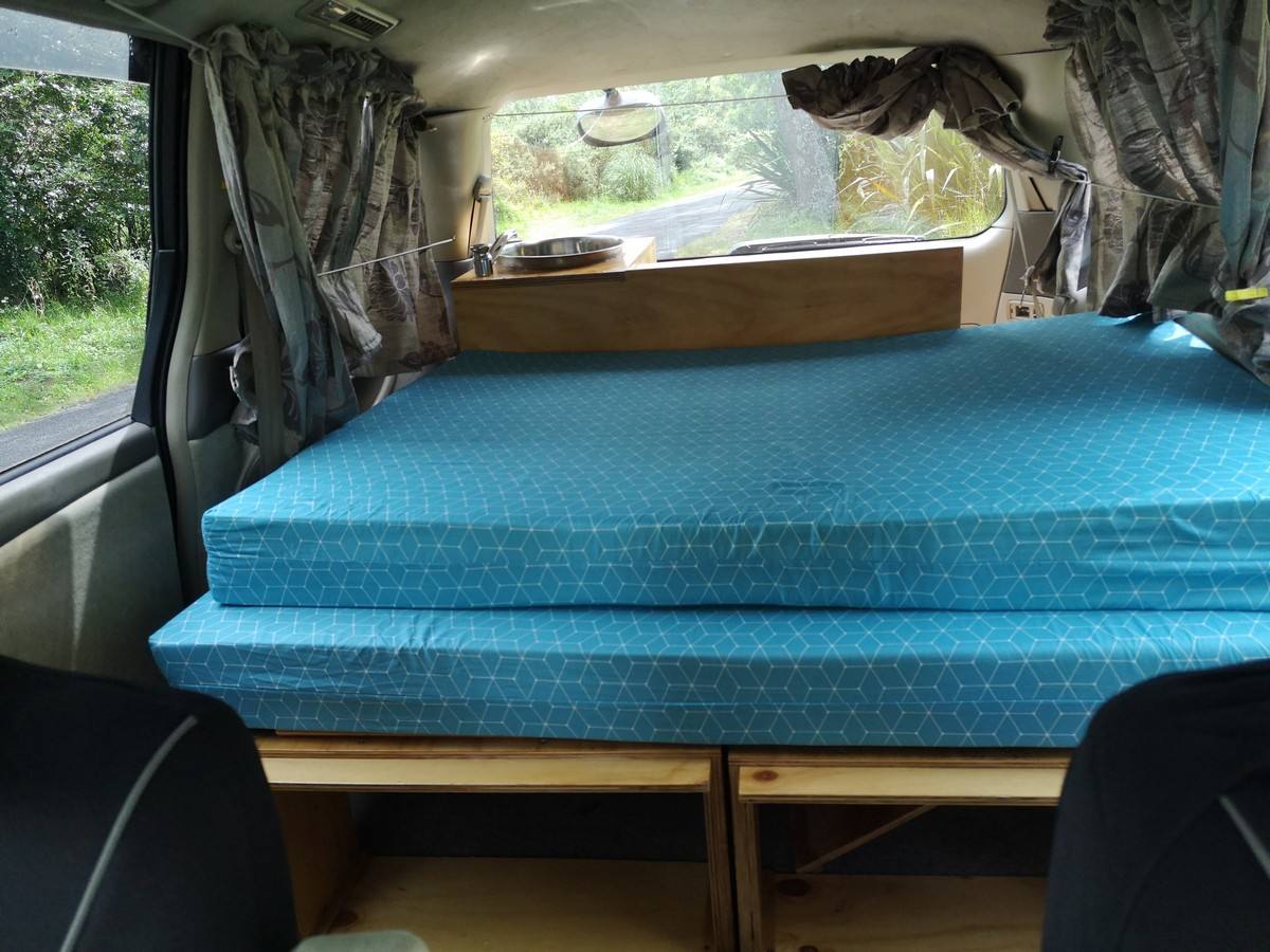 Inside the KBZ76 campervan, double bed made up looking forward to the sink unit and the cab