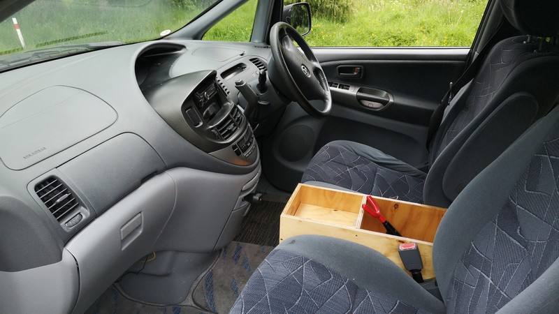 Dashboard and front seats of the FJD528 Toyota Estima, with the plywood console box between them