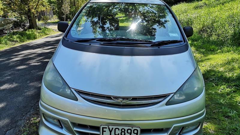 Front of the silver FYC899 Toyota Estima campervan parked on a shaded country road