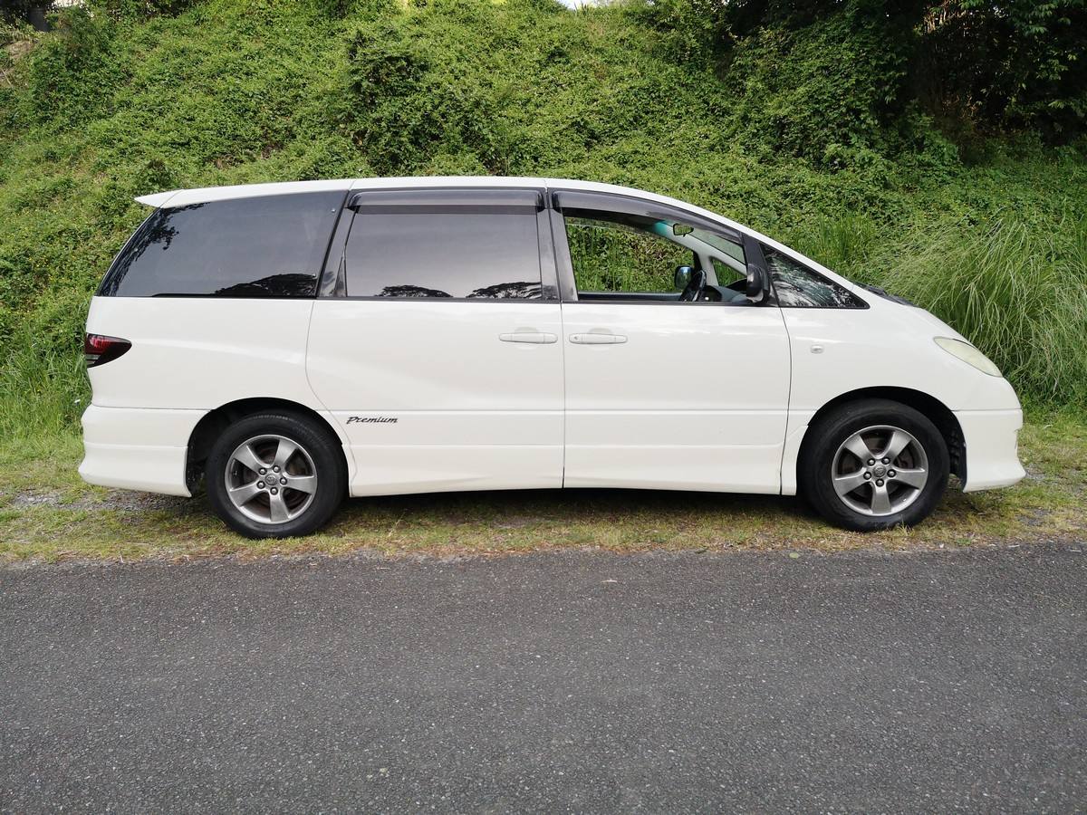 Side view of the white 2005 Toyota Estima campervan JDP67 parked on a country road
