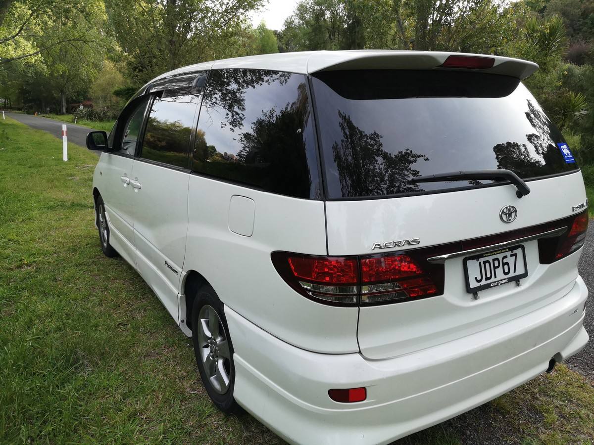 Rear three-quarter view of the white Toyota Estima campervan JDP67 on a grass verge