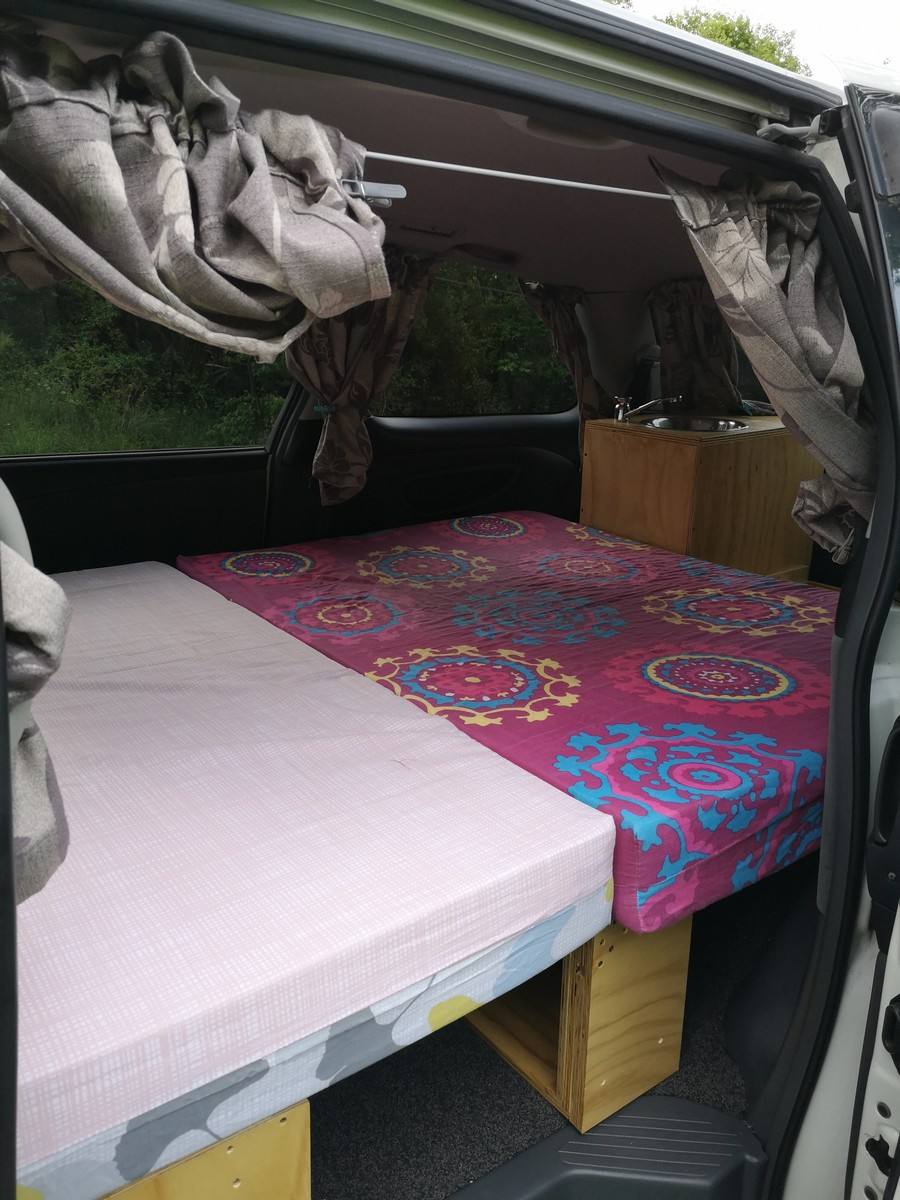Inside the JDP67 campervan, double bed made up across the van with the sink unit alongside