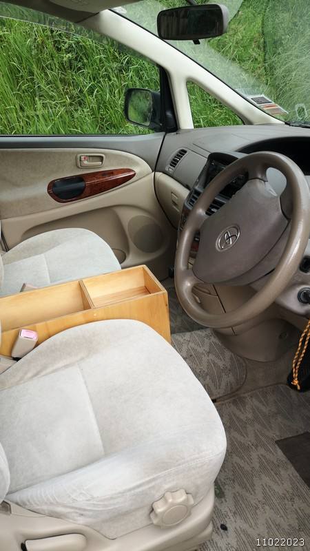 Driver's seat, steering wheel and wood-trim door of the JBB773 Toyota Estima campervan