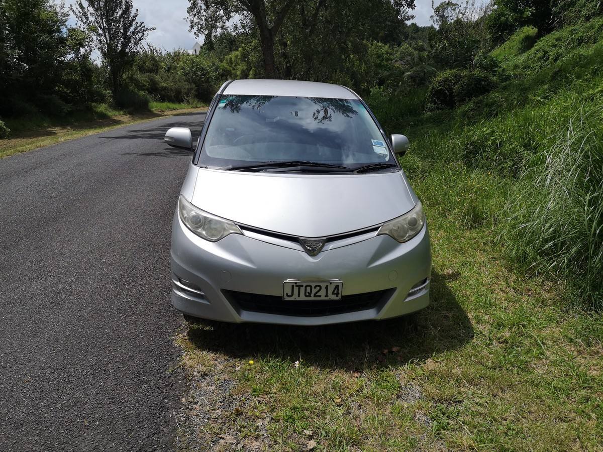 Front of the silver Toyota Estima campervan with registration JTQ214, parked on a road verge