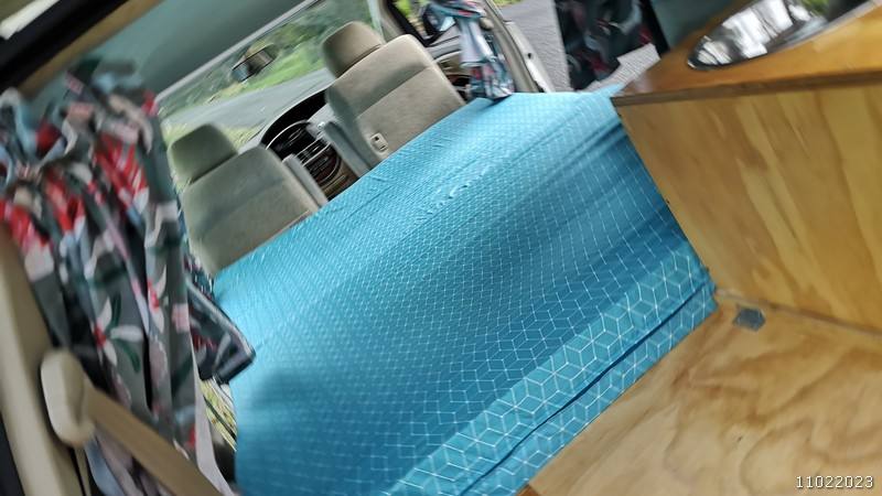 Looking across the JBB773 campervan's made-up bed towards the cab
