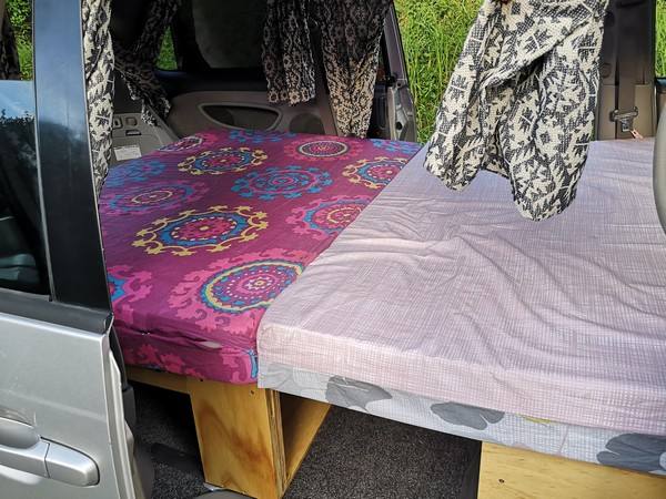 Bed made up in the FPS382 campervan, seen through the open side door