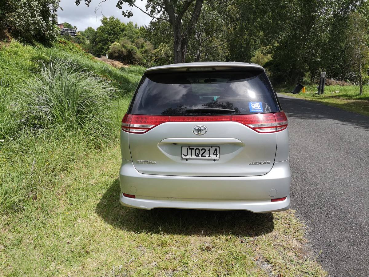 Rear of the JTQ214 Toyota Estima campervan with the registration plate and self-contained sticker