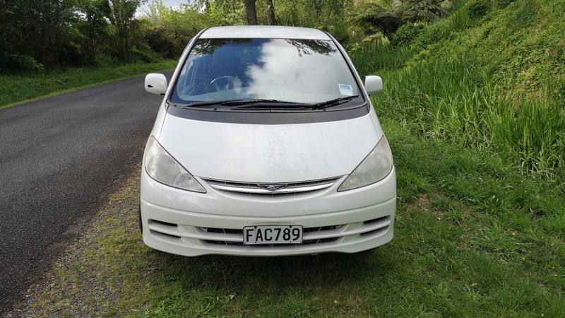 Front of the white Toyota Estima campervan with registration FAC789, parked on a country road verge