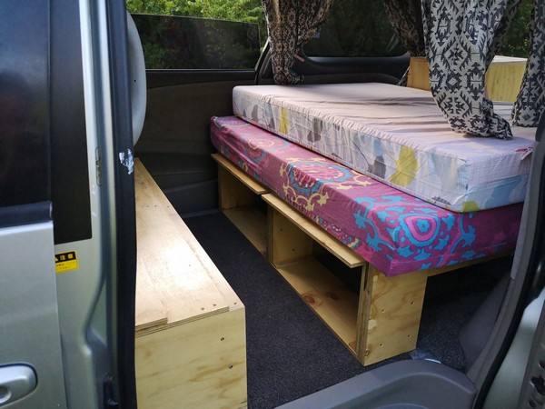 Side door open on the FPS382 campervan, two mattresses on the bed base with storage underneath