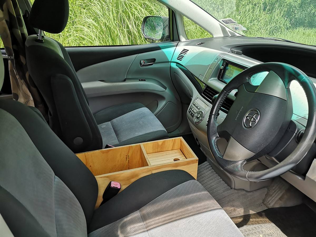 Steering wheel, front seats and plywood console box of the JTQ214 Toyota Estima campervan