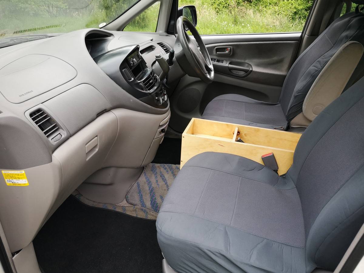 Dashboard and front seats of the EZQ488 Toyota Estima, plywood console box between the seats