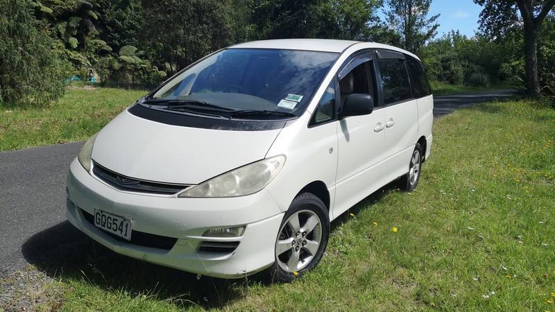 Front three-quarter view of the white GQG541 Toyota Estima campervan parked on grass