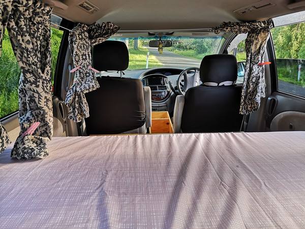 Inside the FPS382 campervan looking forward over the made-up bed to the front seats