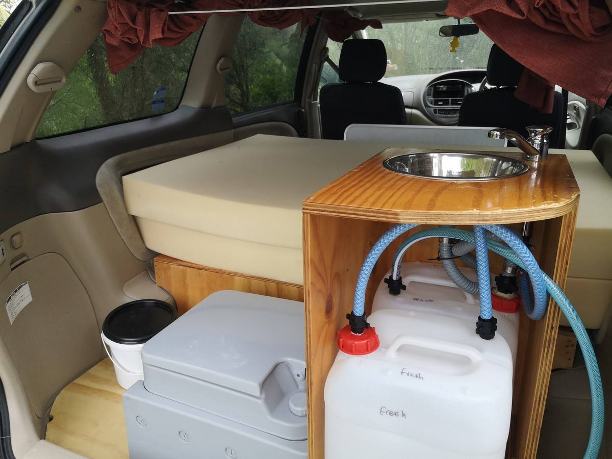 Kitchen unit in the GRH325 campervan with stainless sink, portable toilet and fresh water container below