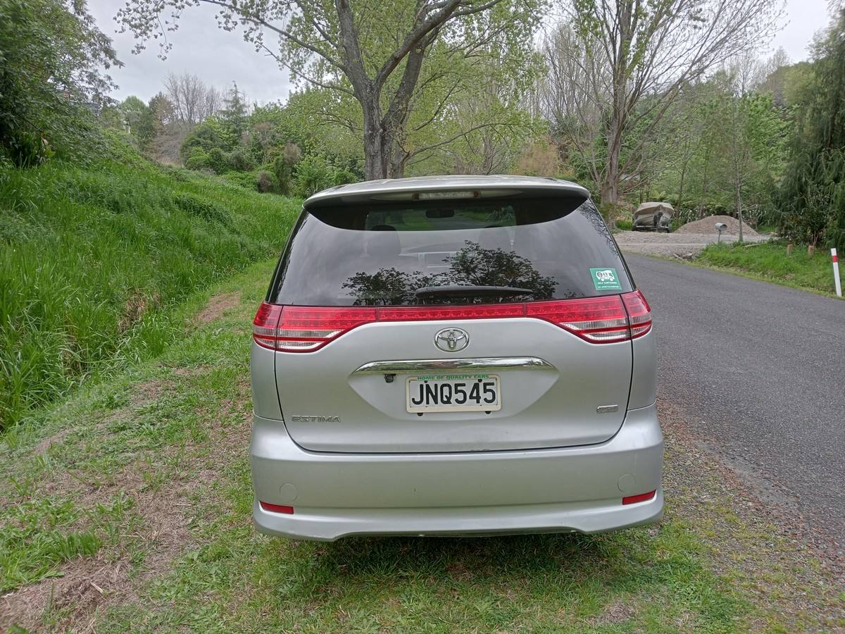Back of the silver Toyota Estima campervan with registration JNQ545 and the self-contained sticker