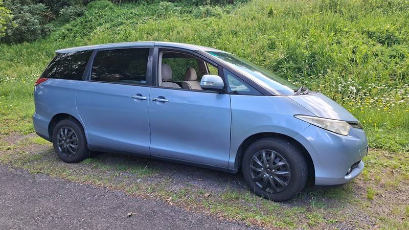 Blue 2007 Toyota Estima self-contained campervan for sale, front three-quarter view from the driver's side