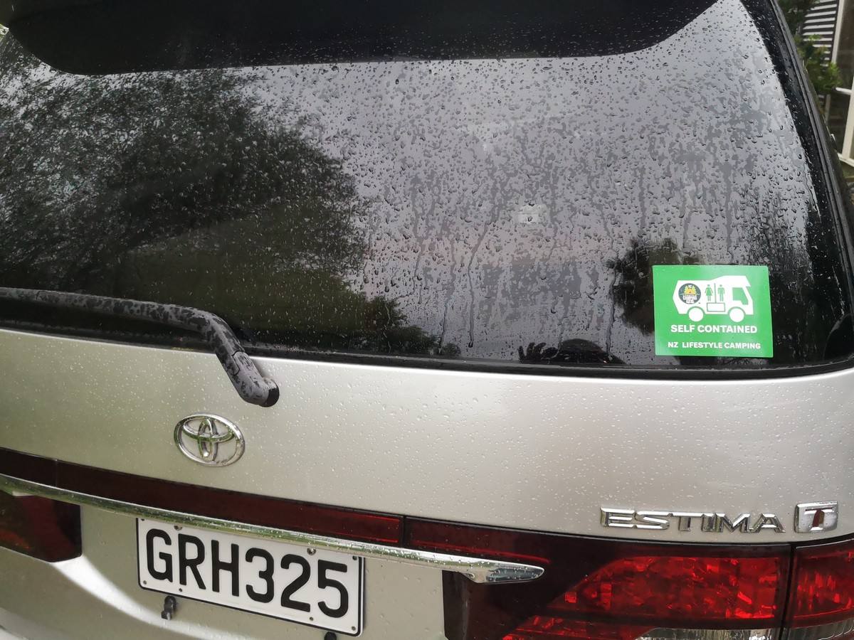 Green self-contained sticker in the rear window of the GRH325 Toyota Estima campervan