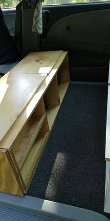 Plywood storage unit built into the back of the GBB26 Toyota Estima campervan, with open shelving
