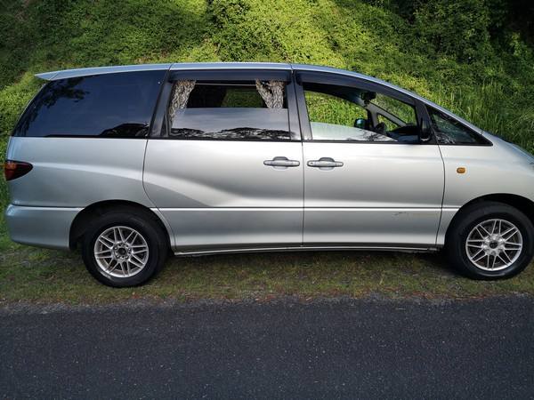Side view of the silver 2001 Toyota Estima campervan FPS382 parked on a roadside verge
