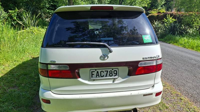 Back of the FAC789 Toyota Estima campervan, with the green self-contained sticker in the rear window