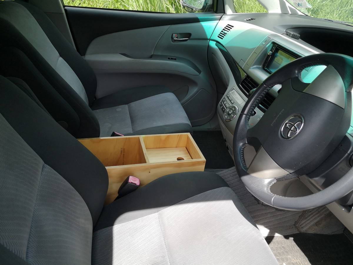 Front seats and dashboard of the JTQ214 Toyota Estima, with the plywood console box between them