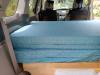 Inside the KHP570 campervan, mattress folded on the plywood bed base