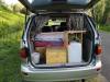 Tailgate open on the FPS382 campervan, showing the bed, kitchen unit and fresh water container