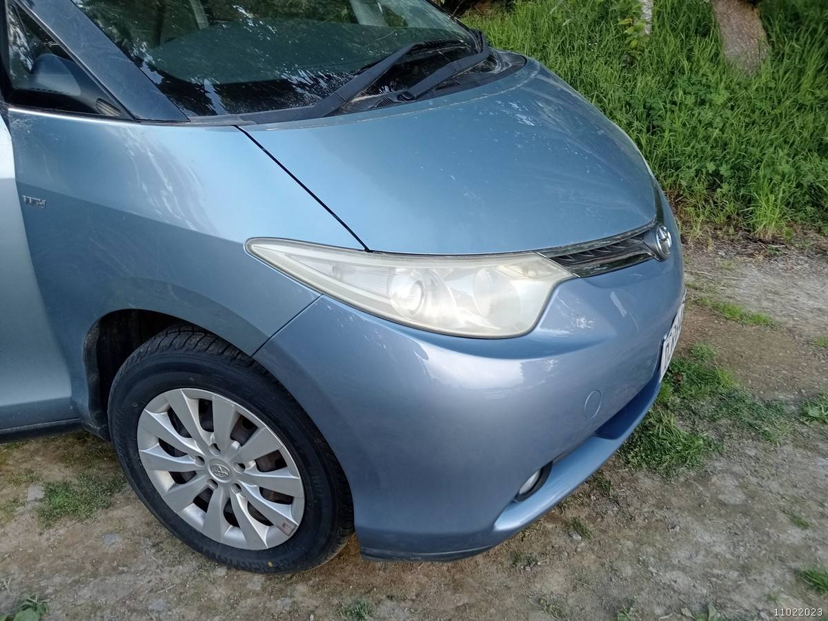 Front corner of the blue DJR846 Toyota Estima campervan, headlight and alloy wheel