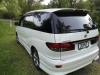 Rear three-quarter view of the white Toyota Estima campervan JDP67 on a grass verge