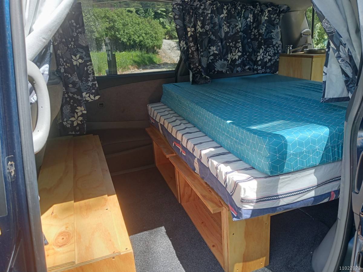 Bed on its plywood base in the FDK492 campervan with the timber bench alongside