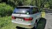 Rear three-quarter view of the FBE338 Toyota Estima campervan, green self-contained sticker visible