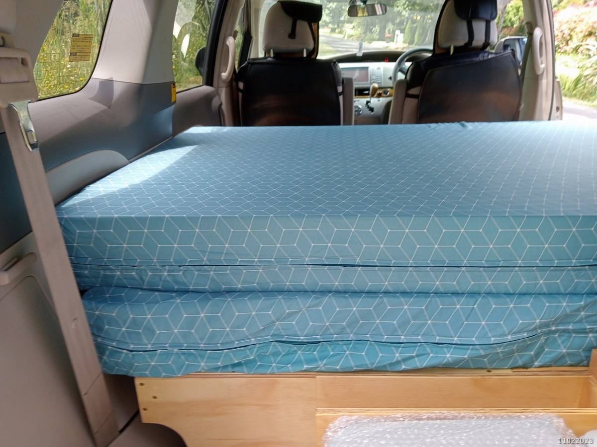 Inside the KHP570 campervan, mattress folded on the plywood bed base