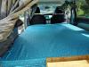 The JTQ214 campervan's double bed made up across the van with the curtains closed