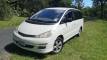 Front three-quarter view of the white GQG541 Toyota Estima campervan parked on grass