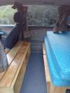Inside the GRH325 campervan, bed on one side and the plywood bench seat opposite