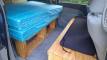 Inside the EYC409 campervan, bed cushion on its timber frame with the bench seat opposite