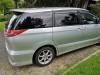 Side view of the silver Toyota Estima campervan JTQ214 parked on a gravel drive