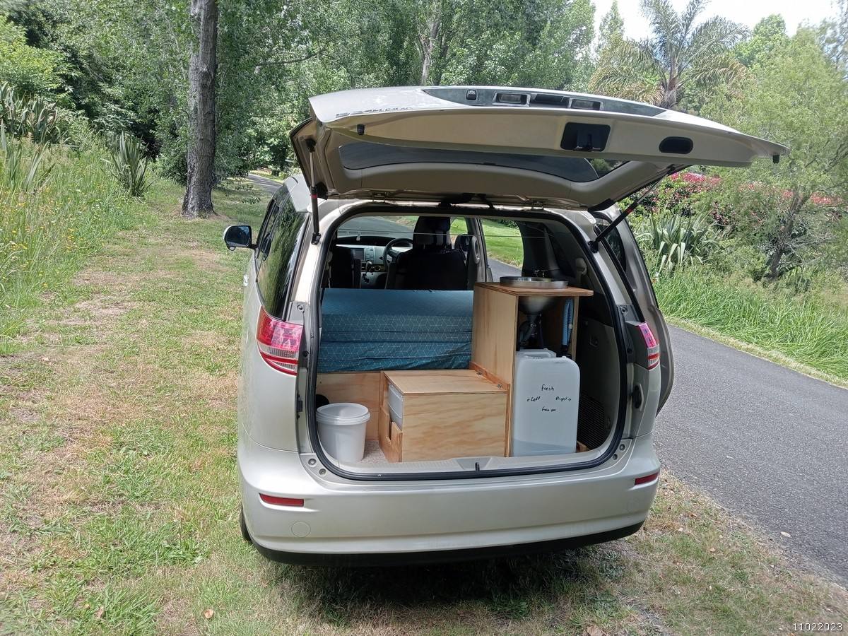 Tailgate open on the KHP570 campervan, showing the bed, kitchen unit and water container