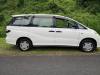 Side view of the white 2002 Toyota Estima campervan EZQ488 parked beside a hedge