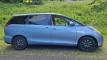 Side view of the blue 2007 Toyota Estima campervan EYC409 parked on a grass verge