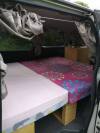 Inside the JDP67 campervan, double bed made up across the van with the sink unit alongside