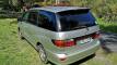 Rear three-quarter view of the silver Toyota Estima campervan with registration FBE338 and towbar