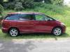 Side view of the red 2006 Toyota Estima campervan JAK653 on a country road