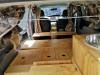 Inside the JTQ214 campervan looking forward over the plywood bed base to the sink unit and cab